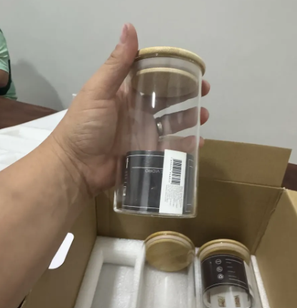 Cliente abrindo a caixa do kit de potes herméticos de vidro