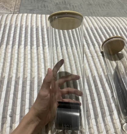 Pote de 2 litros de vidro com tampa de bambu na mão de uma cliente